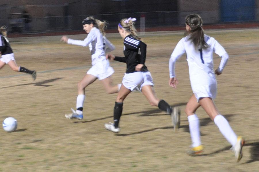 Ansley Warner passing to Marisa Costagliola, attempting to make a goal. 