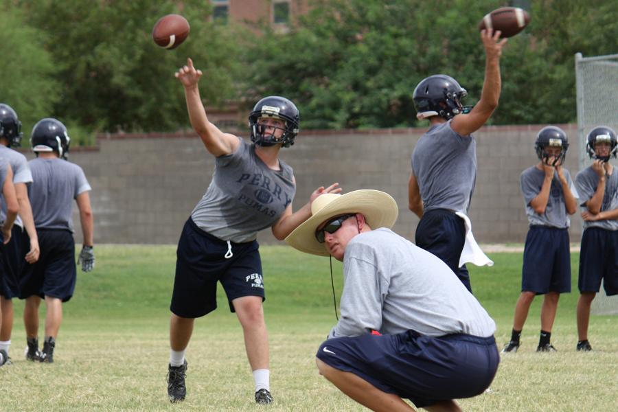 From left: Chad Denton (11), Coach Nathan Harder, Austin Nightingale (11) throwing routes after school on August 5th, 2013.