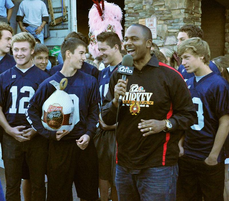 Bruce Cooper of Channel 12 News, broadcasts PHS football players handing out turkeys at Basha’s Supermarket.
The team partnered with the pom and cheer program to raise money to buy families Thanksgiving turkeys.