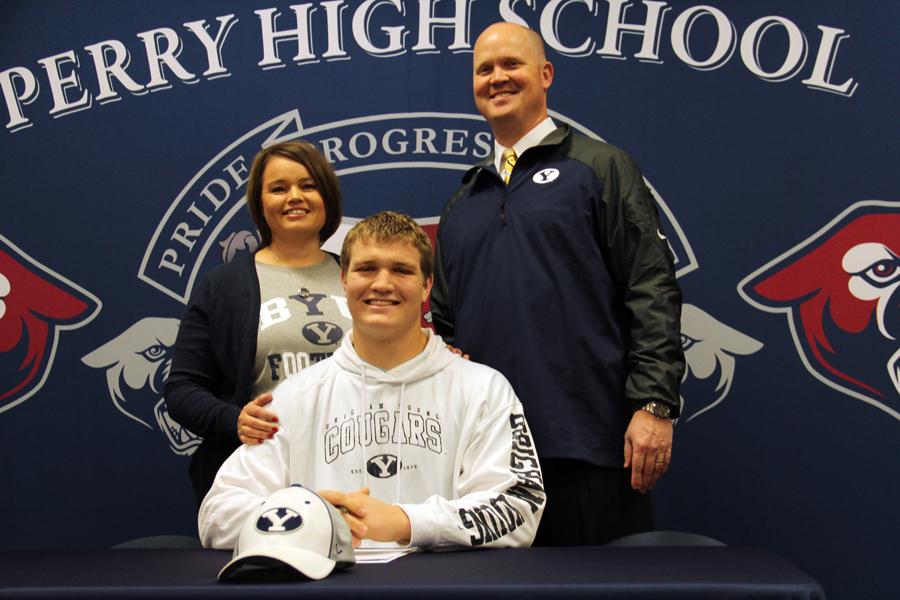 Senior Chandon Herring, with support from family, signs a letter of intent to play football for BYU. 
