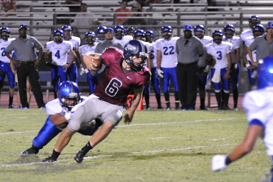 Senior quarterback Austin Nightingale fights to avoid a sack against Tucson Sunnyside. The Pumas toppled the Blue Devils, 53-18 in the first game of the season.