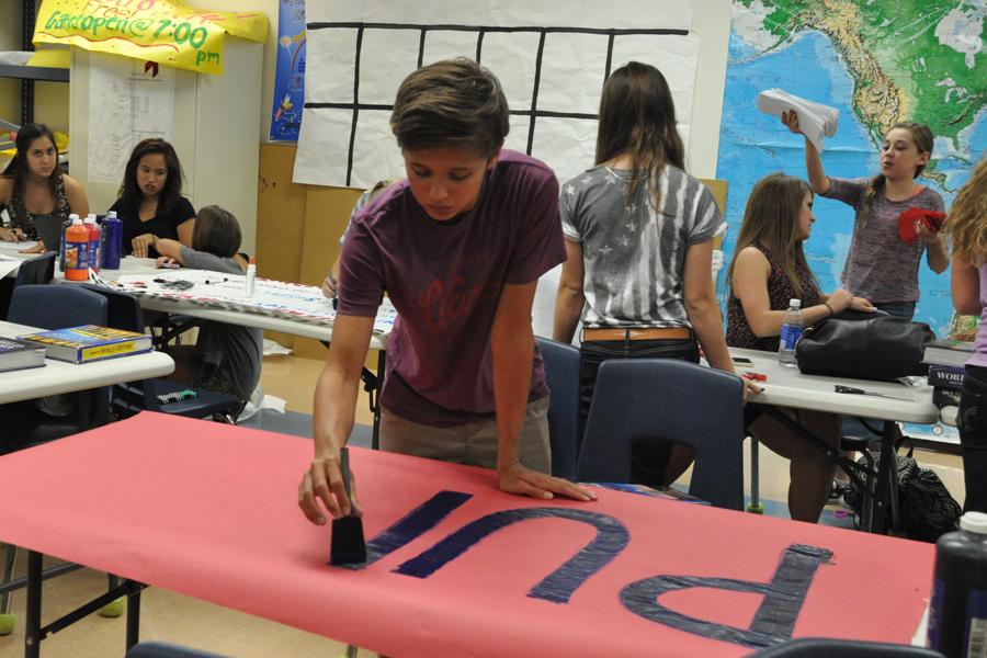 Sophomore Aaron Clouse paints a poster for the homecoming assembly. Homecoming is slated for Sept. 13.