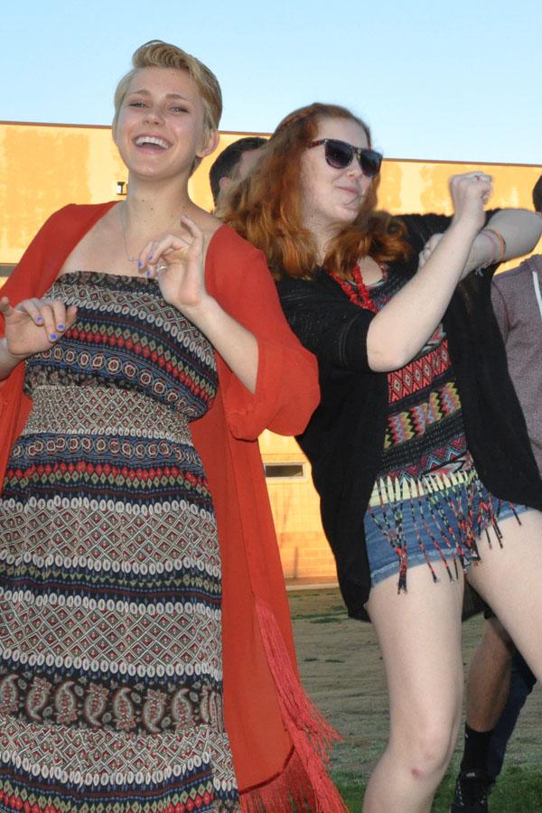 Mackenzie Ness and Dayna Miller dress in Coachella attire, dance in the courtyard.