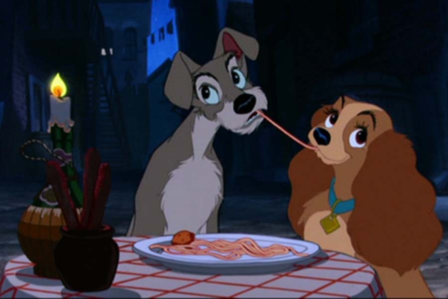 The canine leads of Lady and the Tramp share an iconic noodle of spaghetti (Disney).