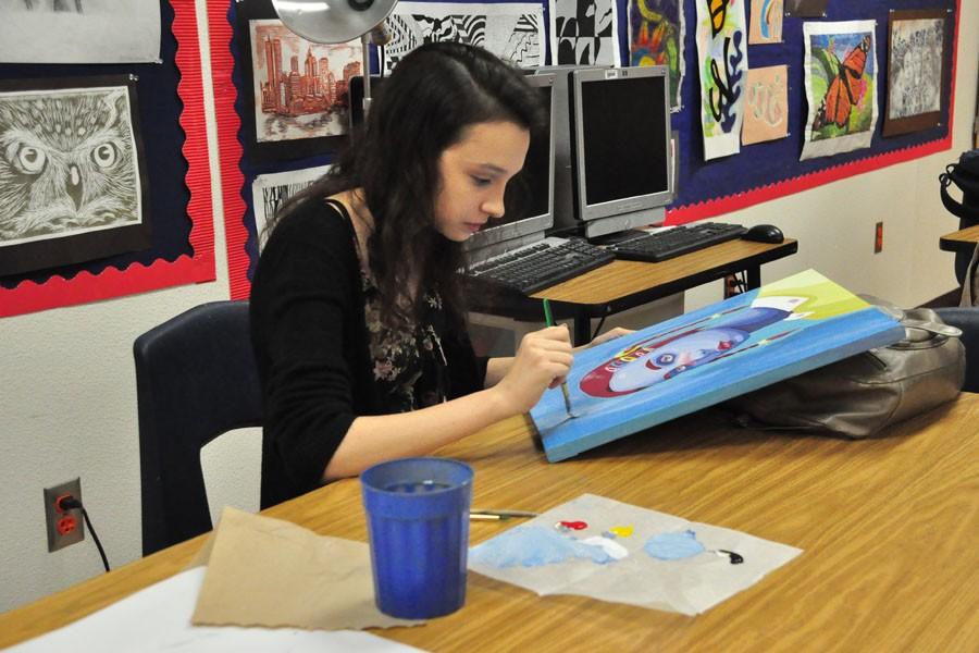 Abigail Starkey working on a painting in her art class.