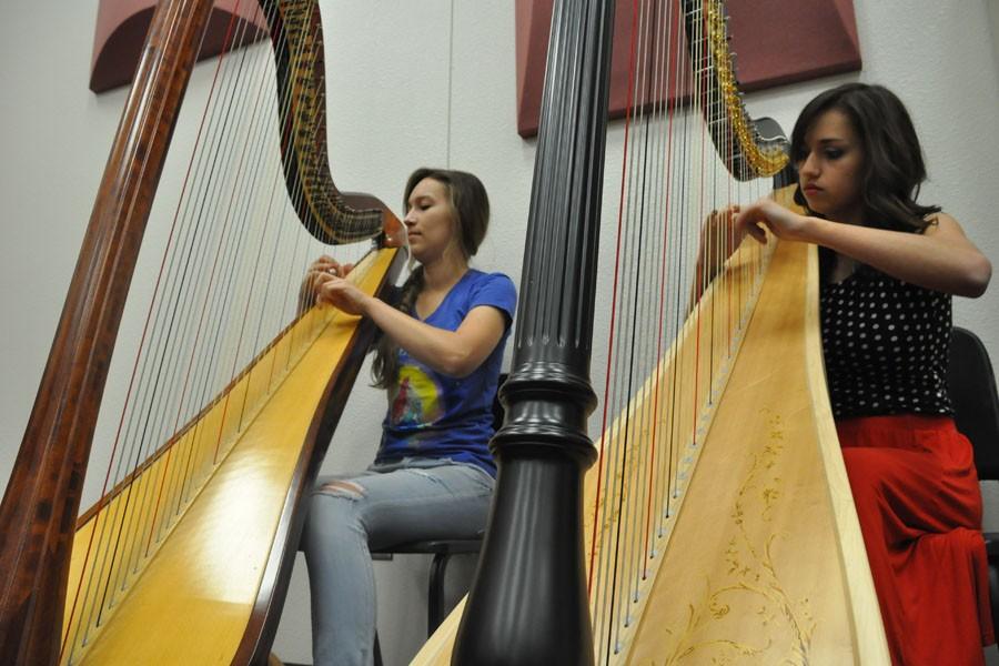 Senior Victoria Bull (left) and junior Hannah Butcher practice harp during their first hour chamber orchestra class. Bull and Butcher began playing harp when they both were nine, and joined orchestra when they were freshmen.