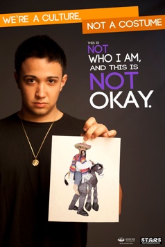 A boy holds a picture of a Mexican costume with a very obvious message This is not okay
 branded across the front. The movement has been gaining more attention on Twitter.