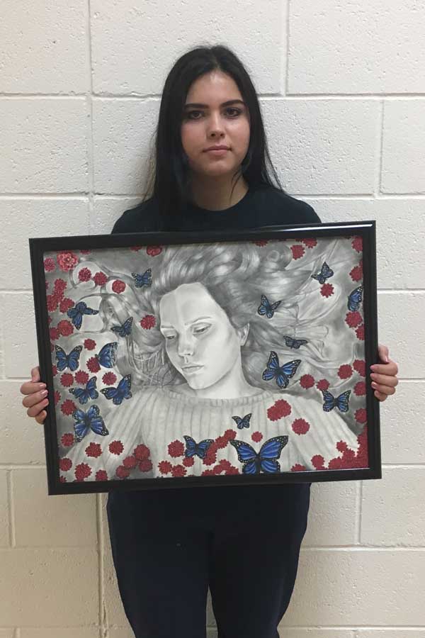 Isabell Martinez holding her self portrait. 