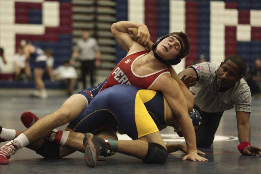 Junior Travis Calloway (in red) fights to pin opponent in the Puma Duals.
