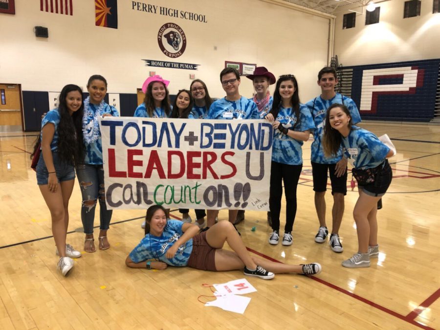 Link Crew holds a banner at freshmen orientation, familiarizing the freshmen with the campus.