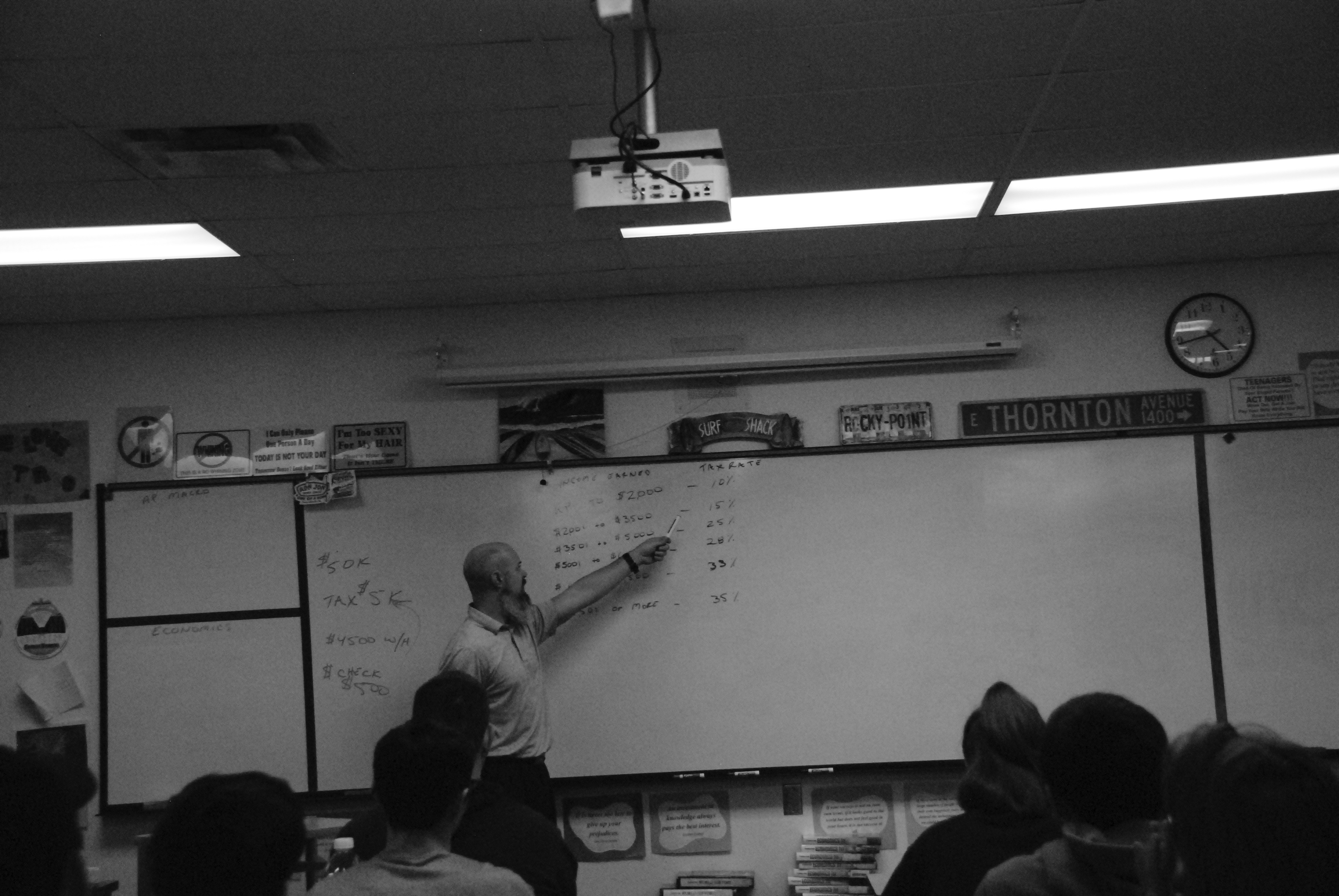 Thornton lectures his students on economics using his own form of currency inside the classroom.