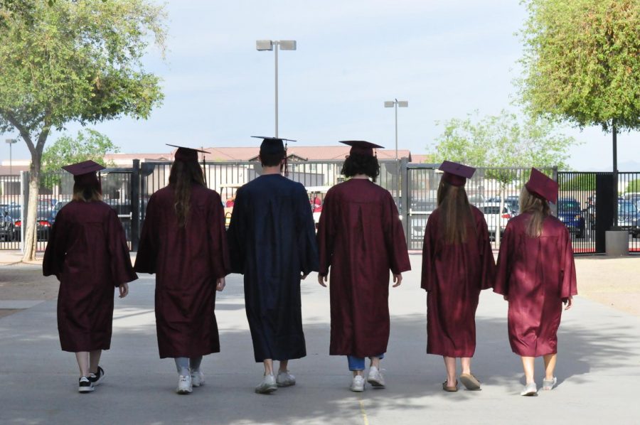 Seniors: Gavin Brennan, Makayla Premo, Anna Myers, Dayton Jones, Ashlyn Minor, and Nadine Loureiro wear their cap and gown while walking off-campus. After their abnormal four years of high school these seniors are ready to start their new life.