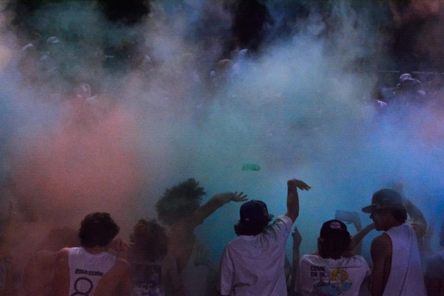 Perry student section throws color powder into the air at the homecoming game against Casteel. The pumas may have lost to Casteel, but the student section kept up the energy all night. 