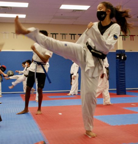 Junior black belt Minami Pituvong practices her skills at training. She is working with kids to help teach them Taekwondo as well.