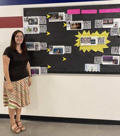 German teacher Sandra Zemaitis standing with the completed march music bracket. Throughout the month of Mar. students voted on their favorite songs from the German charts to complete the bracket. 