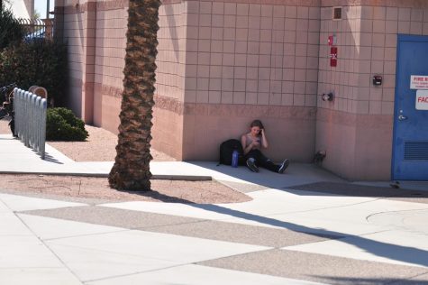 Student doing homework outside of the school in order to catch up with her assignments.