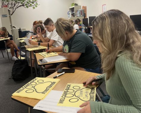StuGo prepares signs to welcome back students on campus. They posted the signs in the cafeteria with each students name written on a sheet of paper. 