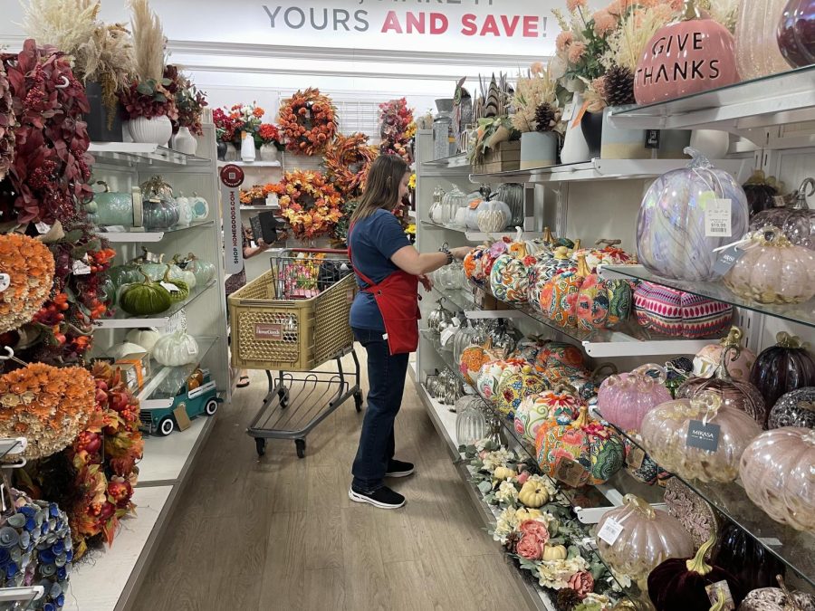 HomeGoods employee organizes seasonal section. The retail store has a wide selection of fall decor. 