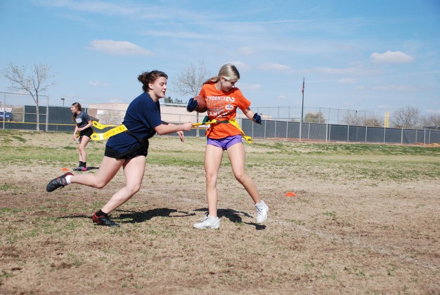 Sophomore Elizabeth Franklin pulls junior Peyton Tanghe’s flag during practice. After becoming an AIA sanctioned sport, the girls flag football team is practicing more regularly to prepare themselves for the upcoming season.