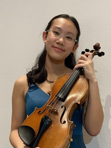 Sophomore Charlotte Yeh holding the violin. She practiced the song Barber Violin Concerto , which is the song she will play at Carnegie Hall.