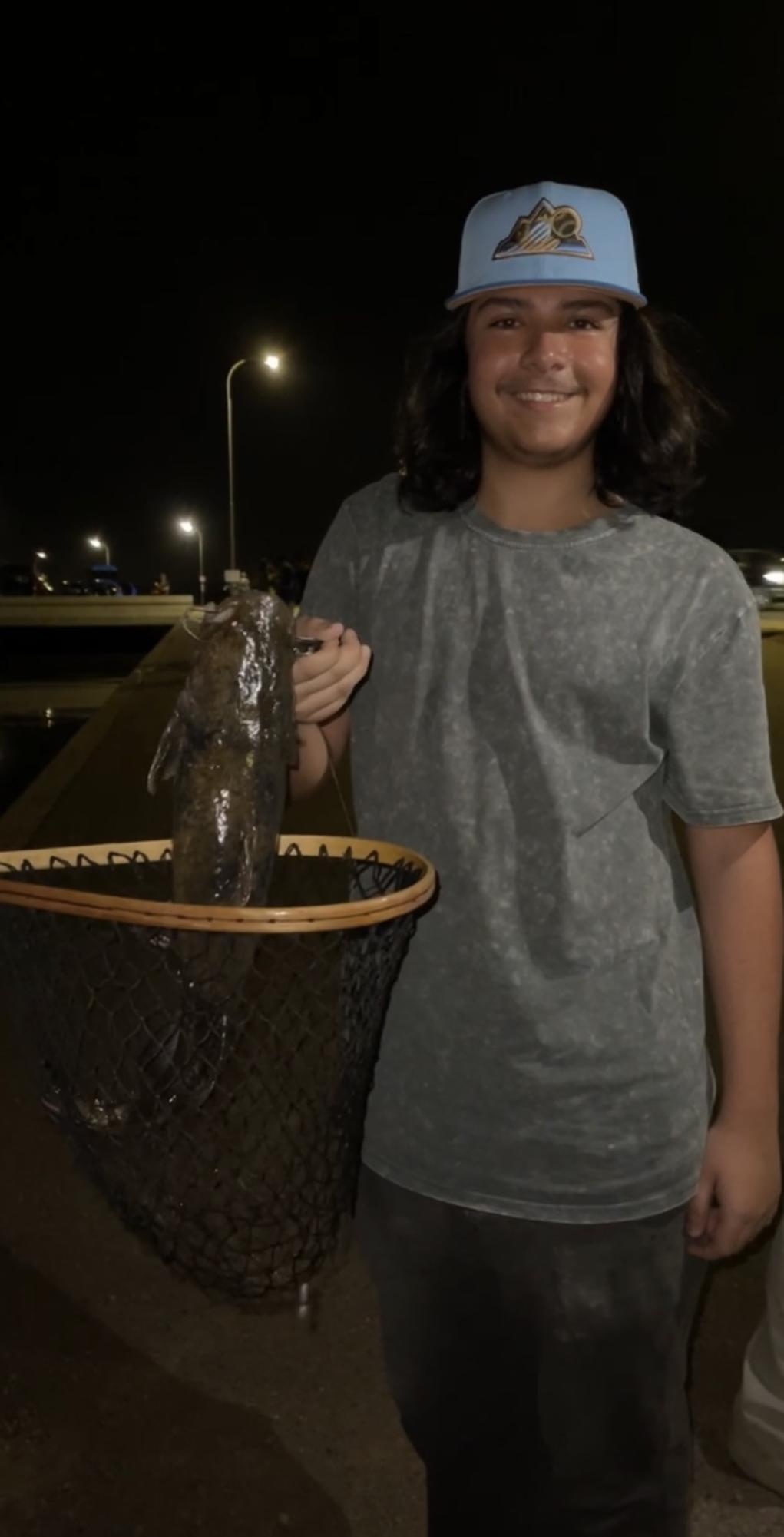 Senior Angel Barillas holds up a catfish he caught in the city canal. Due to the Community Fishing Program, fish like this are abundant in the canals.