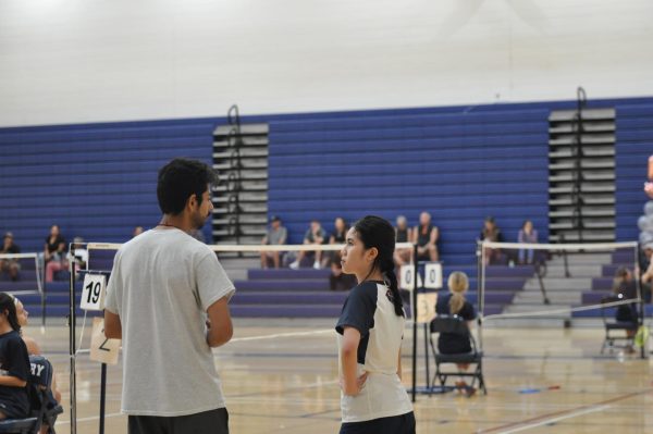 During matches, coaches give advice to their players. Junior Robin Bui receives advice from one of her coaches in preparation for her game.