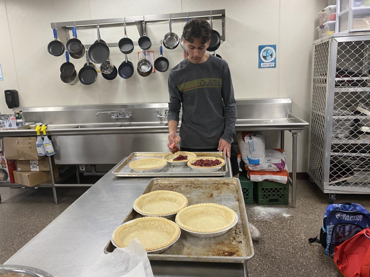 +Senior+Jack+Barkett+pouring+in+pie+filling+in+the+pie+mold.+Students+made+pie+to+fulfill+pie+orders.