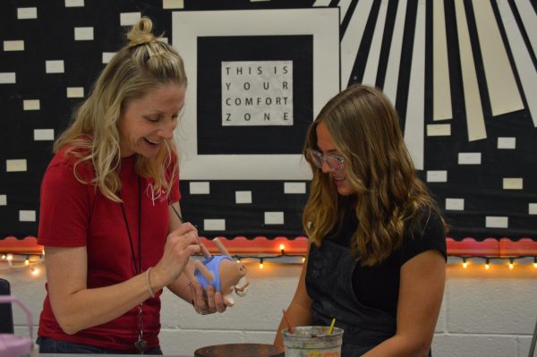 Sculpture teacher Sharon Biemond helps out Sophomore Amy Vos with her pig sculpture project. Biemond is assisting her with painting. 