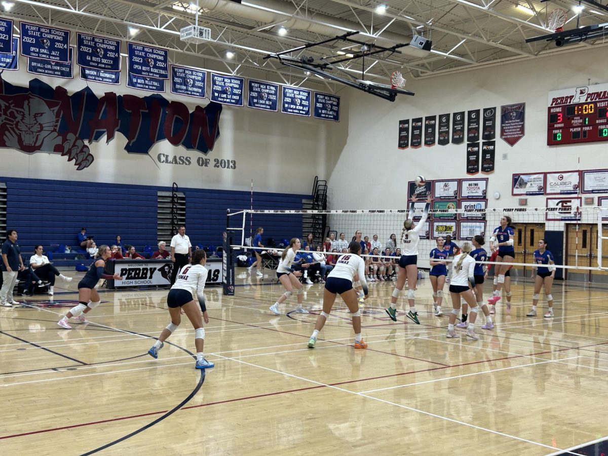 Kenna Cogill (3) reaches up to block the ball across the net after a hit from a
player on Mountain View’s team. Girls volleyball played against Mountain View
High School with a final score of 3-2.