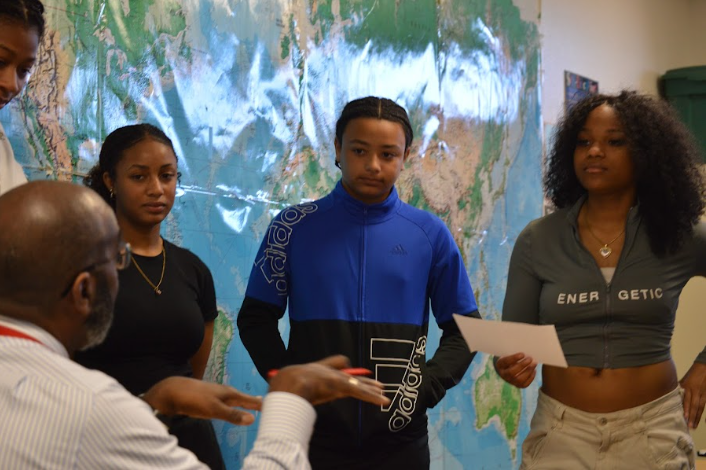  John protrho explaining to freshman Lauryn Pight, freshman Davian Tiggs and freshman Marianna Johnson on what to say during the Black History Month announcements.