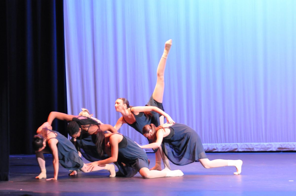 Dancers crowd together in a tight formation as they move in perfect unison, showing the hours of practice that went into the winter dance concert. Their closeness on stage reflects the teamwork they relied on to bring the performance to life.