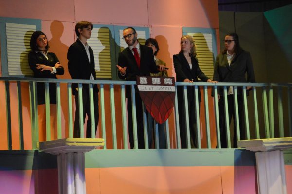 (Left to right) junior Slylvia Fuller, sophomore Remington Hess, senior Alex Bagdasarian, junior Mia Thiel, junior Cassie Tanner, junior Sarah Bouck stand in a line on the second floor of the Legally Blonde house. The group performed a sharp scene depicting the moment of the murder and the reveal of the case they would take on.