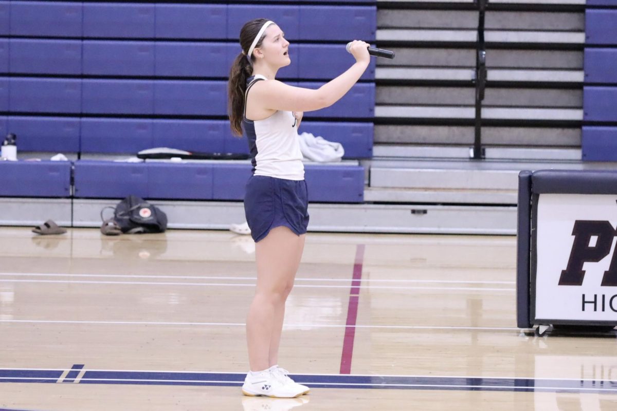 Junior Riley Hunt signs National Anthem at badminton game, a hobby she began shortly after trying out for the team her freshman year 